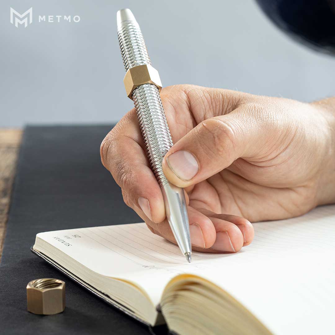 Aluminium MetMo Pen Writing in a book