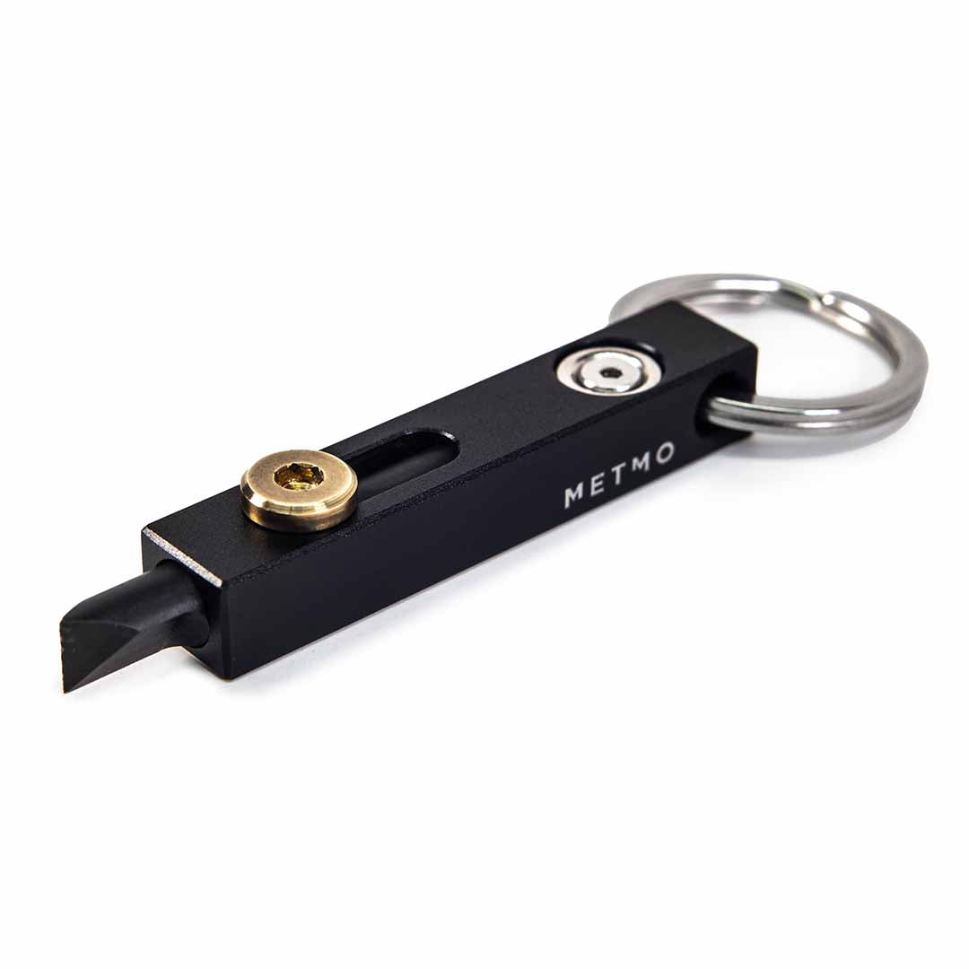 Black and brass metmo edge tool on a white background
