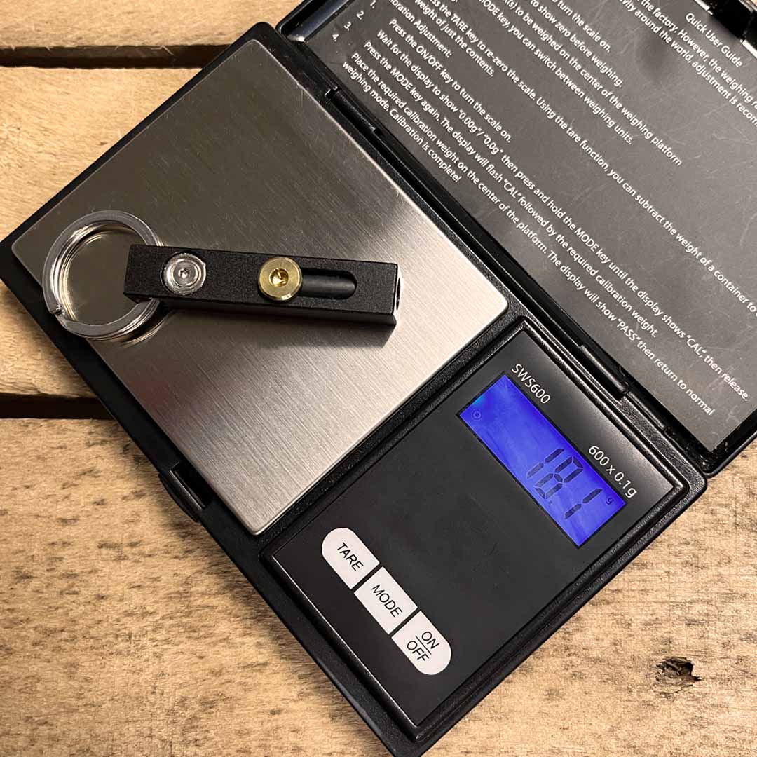 Digital pocket scale weighing a MetMo Edge on a wooden surface