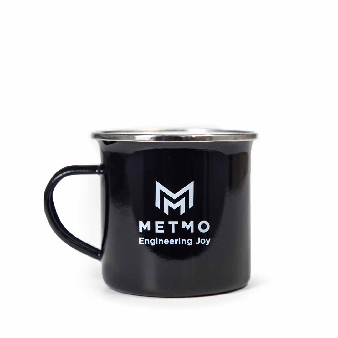 Black mug with METMO Engineering Joy logo on a white background
