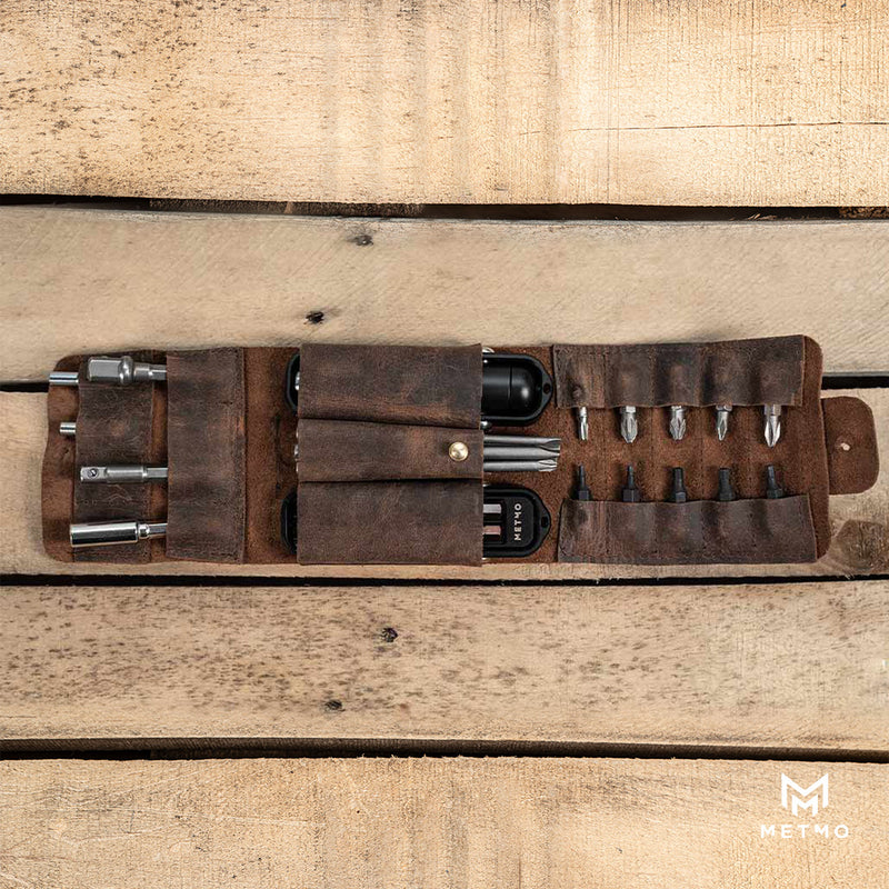 MetMo Pocket Driver and different sized bits and shanks in a brown leather case on a wooden surface