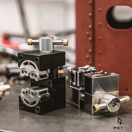 metmo fractal vice in black aluminium and stainless steel stood on metal workbench