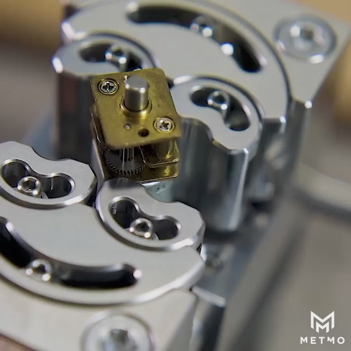 Load video: close up of silver fractal vise closing around a small brass motor