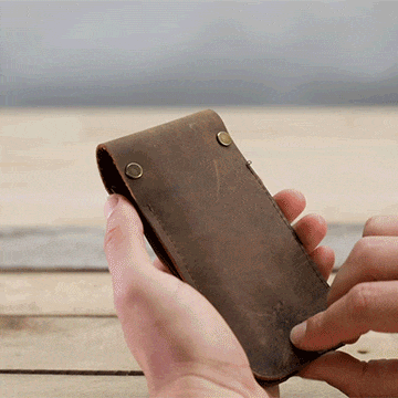 Person removing the MetMo Multi Drive out of the MetMo Multi Drive Leather Case.