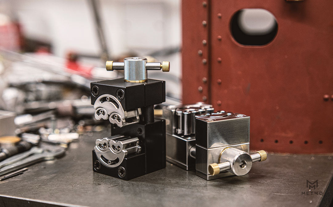 Hero shot of black and stainless steel Fractal Vises on a workbench