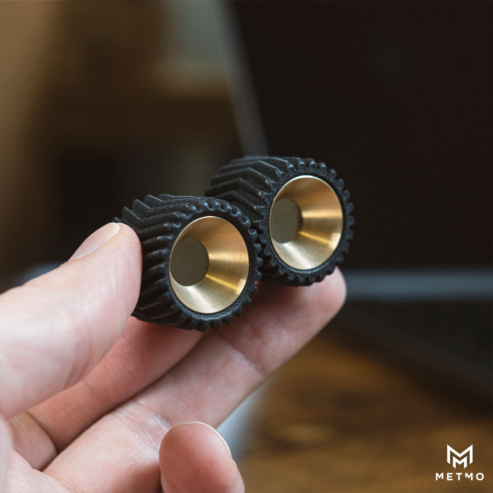 Holding MetMo Helico in fingers on a computer desk 