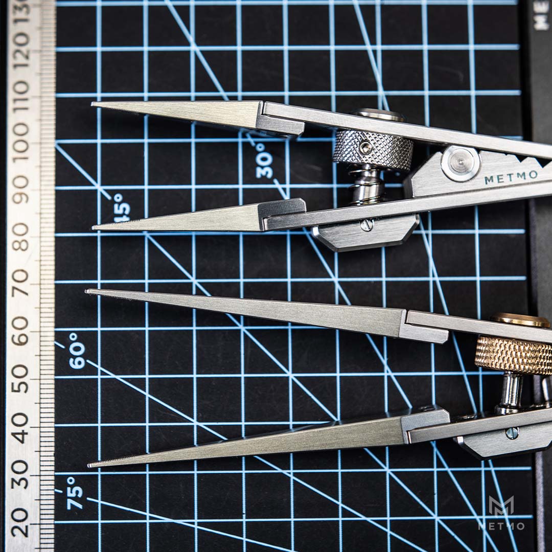 Close-up of several metal precision tweezers. The tweezers are shown in steel finishes, with one pair featuring brass adjustment screws.