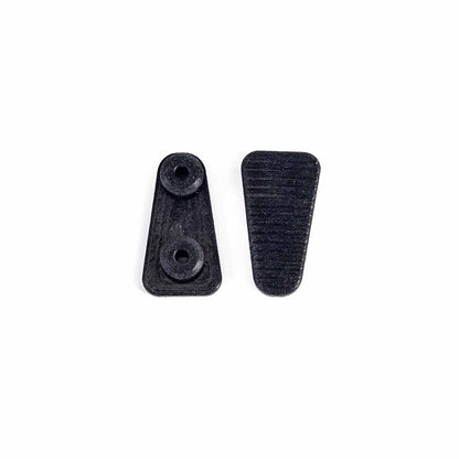 Two small black silicone hardware pieces, one showing the back with two circular holes and one showing the front with a textured surface, shown on a plain white background.