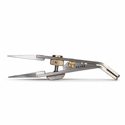 A METMO precision tweezer tool with titanium jaws and brass adjustment knobs, shown on a clean white background.