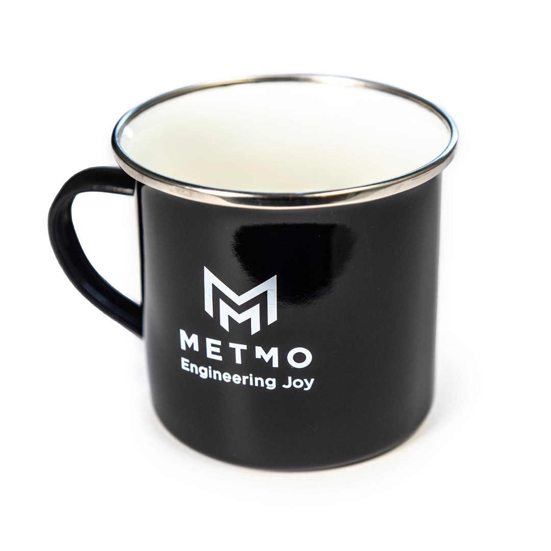 Black mug with white interior and 'METMO Engineering Joy' logo on a white background