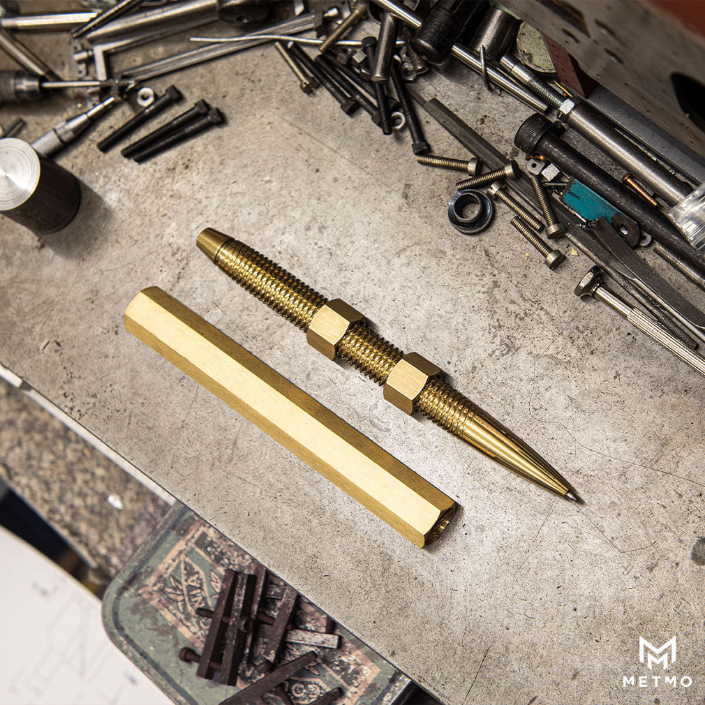 MetMo Brass Pen in the workshop, surrounded by engineering instruments