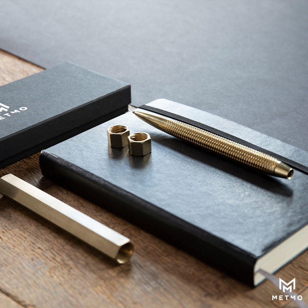 MetMo Brass pen on a writing desk.
