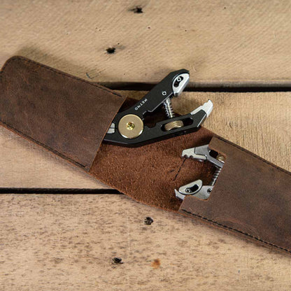 Multitool in leather wallet on a wooden surface