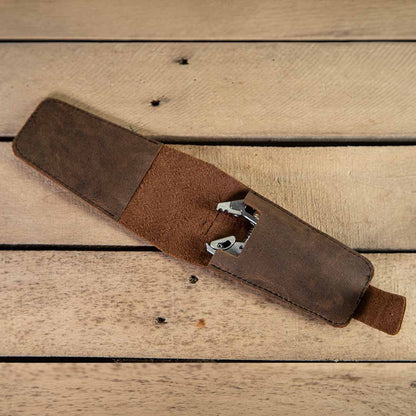 Brown leather tool belt on a wooden surface