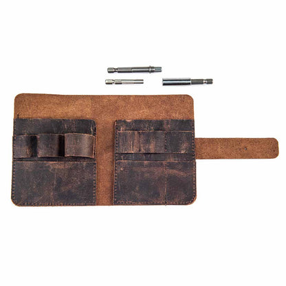 Brown leather tool roll with three metal bits on a white background