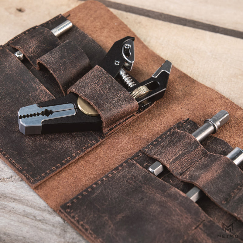 Close up of a black pocket grip multi tool stowed in the leather tool roll