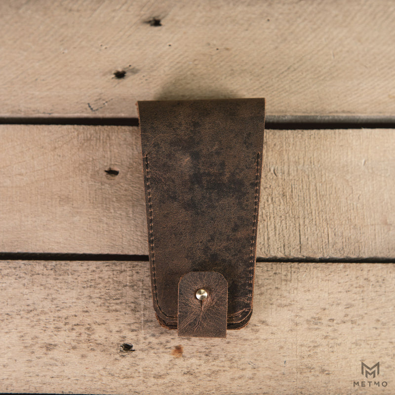 Leather pouch with brass fixings on a wooden slatted surface