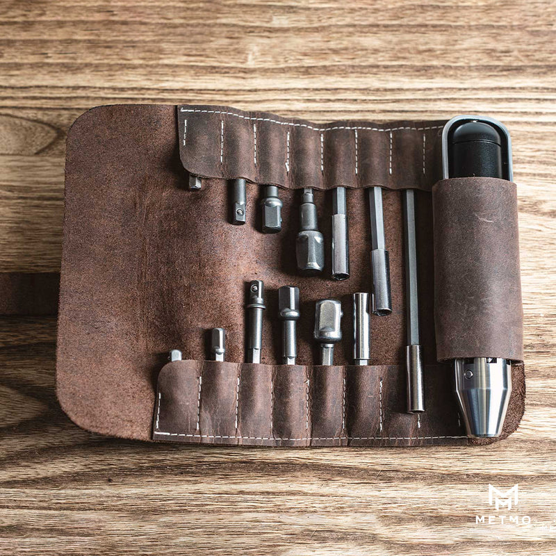 MetMo Driver and  different sized bits and shanks in a brown leather case on a wooden surface