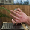 Close up of hand at desk playing with silver helico fidget