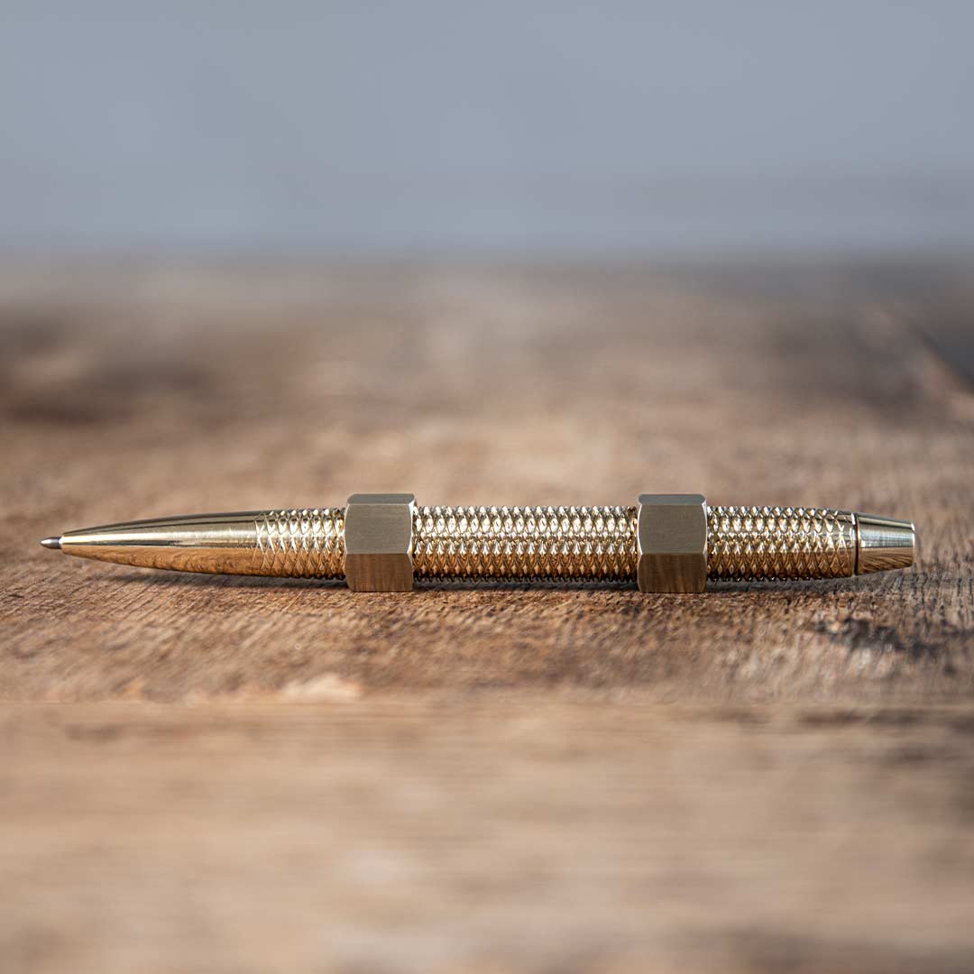 MetMo dual-threaded Brass Pen with Brass Nuts on a desk