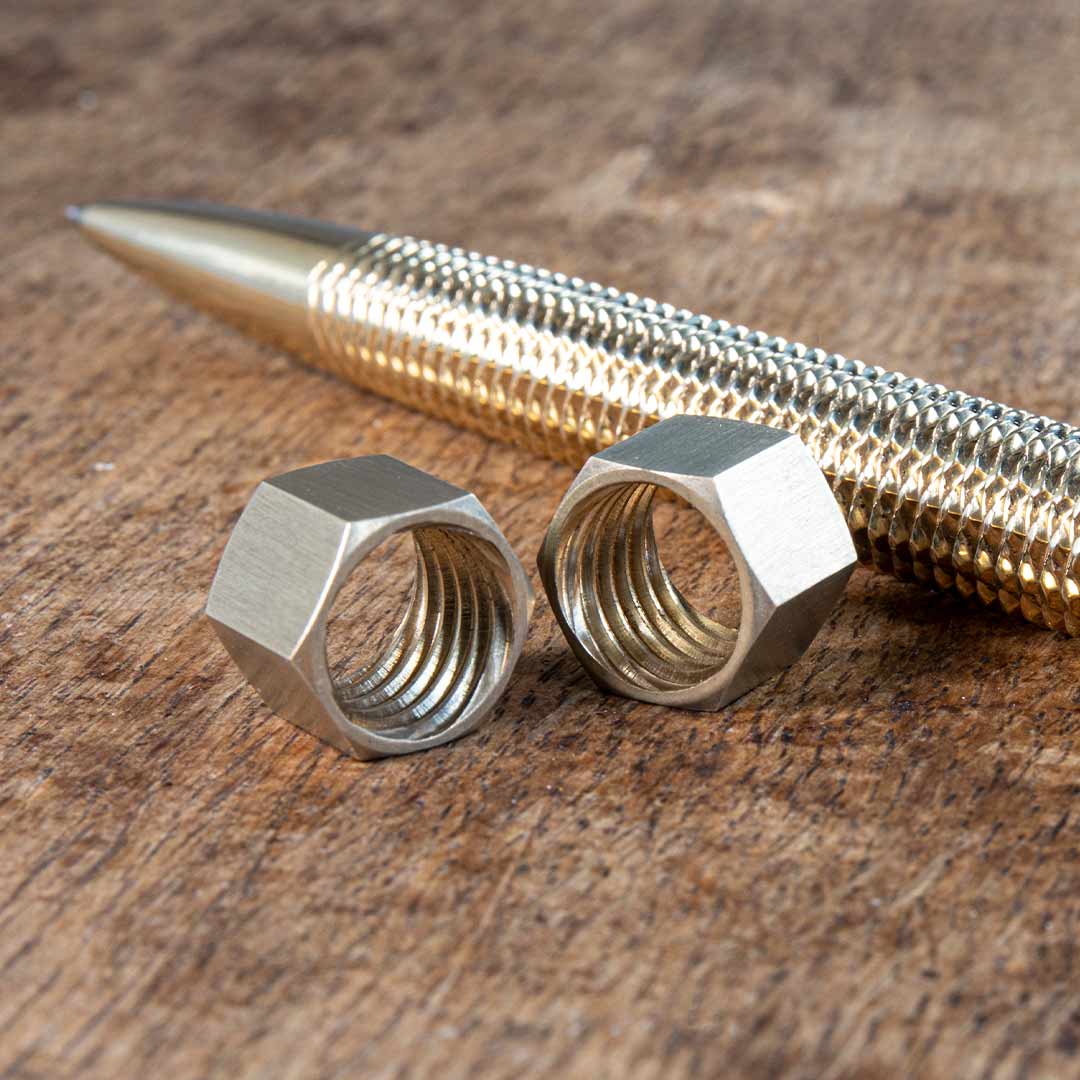 Two screw nuts alongside the Metmo brass pen.